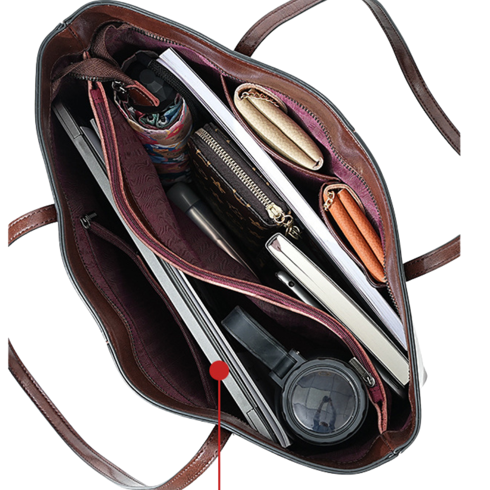 Open brown leather bag with various items including a laptop, phone, and wallet.