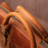 Close-up of a brown leather bag with visible stitching and handle.