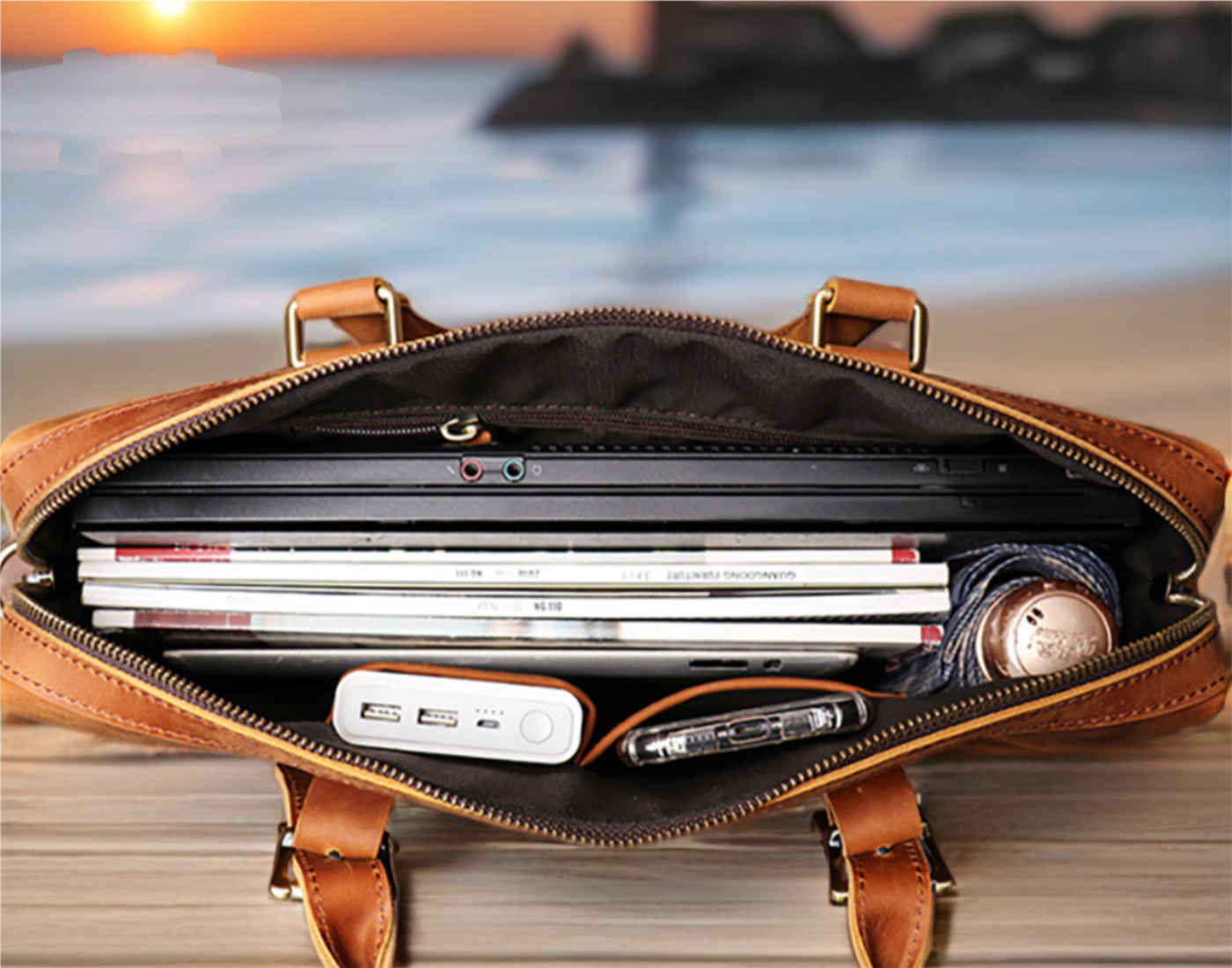 Open leather briefcase with laptop and documents against a blurred outdoor background