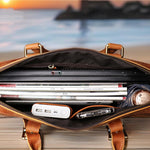 Open leather briefcase with laptop and documents against a blurred outdoor background